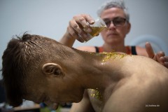 Der Goldglitter wird auf Saschas Körper aufgetragen. (Foto: Barbara Frommann)